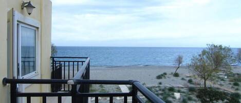 A balcony with a view of the sea and beach.