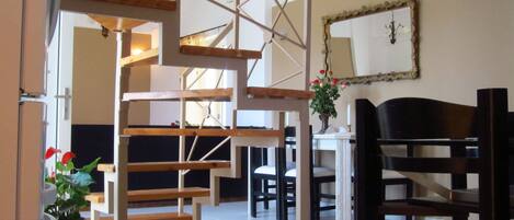 A modern interior with a staircase, wooden furniture, and a mirror on the wall.