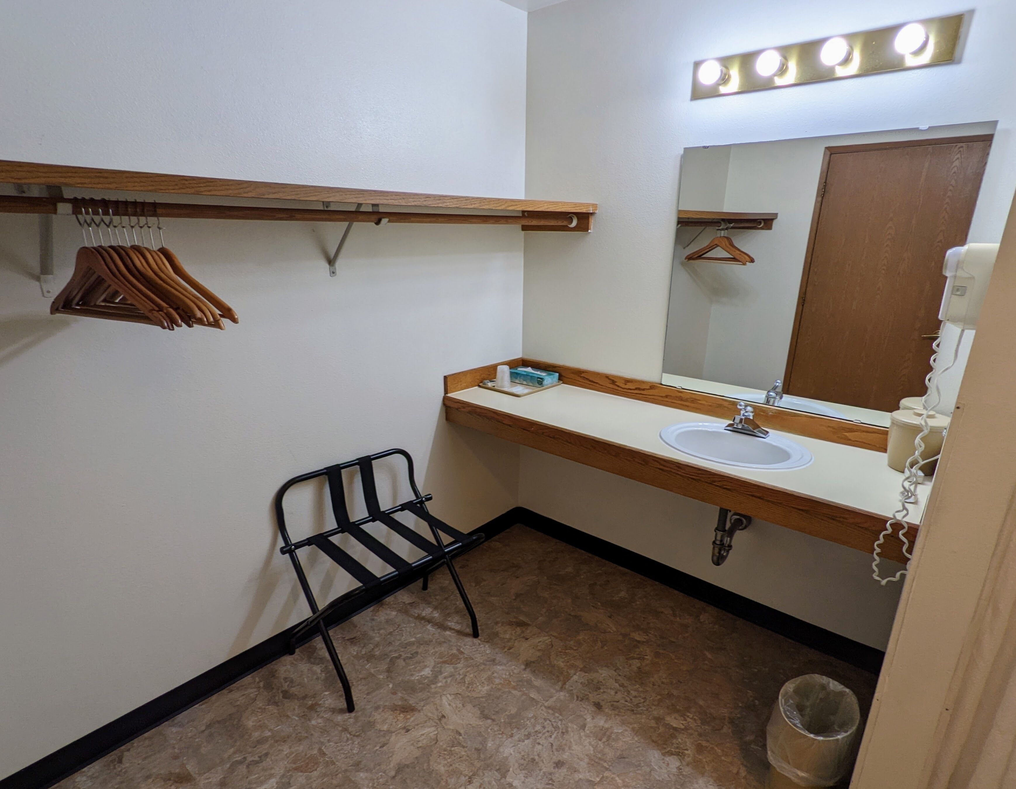A small bathroom with a sink, mirror, and towel rack.