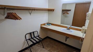 A small bathroom with a sink, mirror, and towel rack.