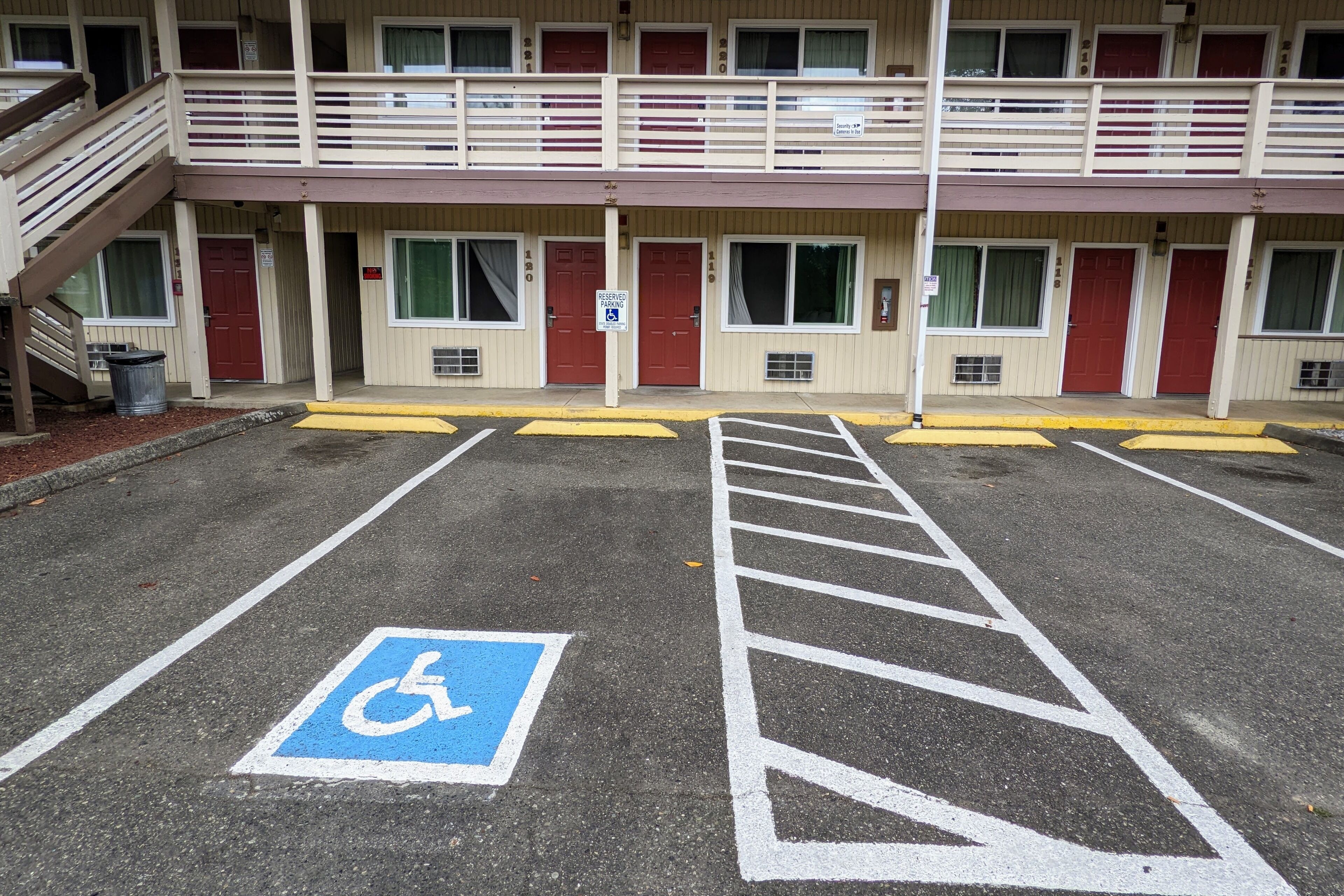 A multi-story hotel with a parking lot marked for disabled access.