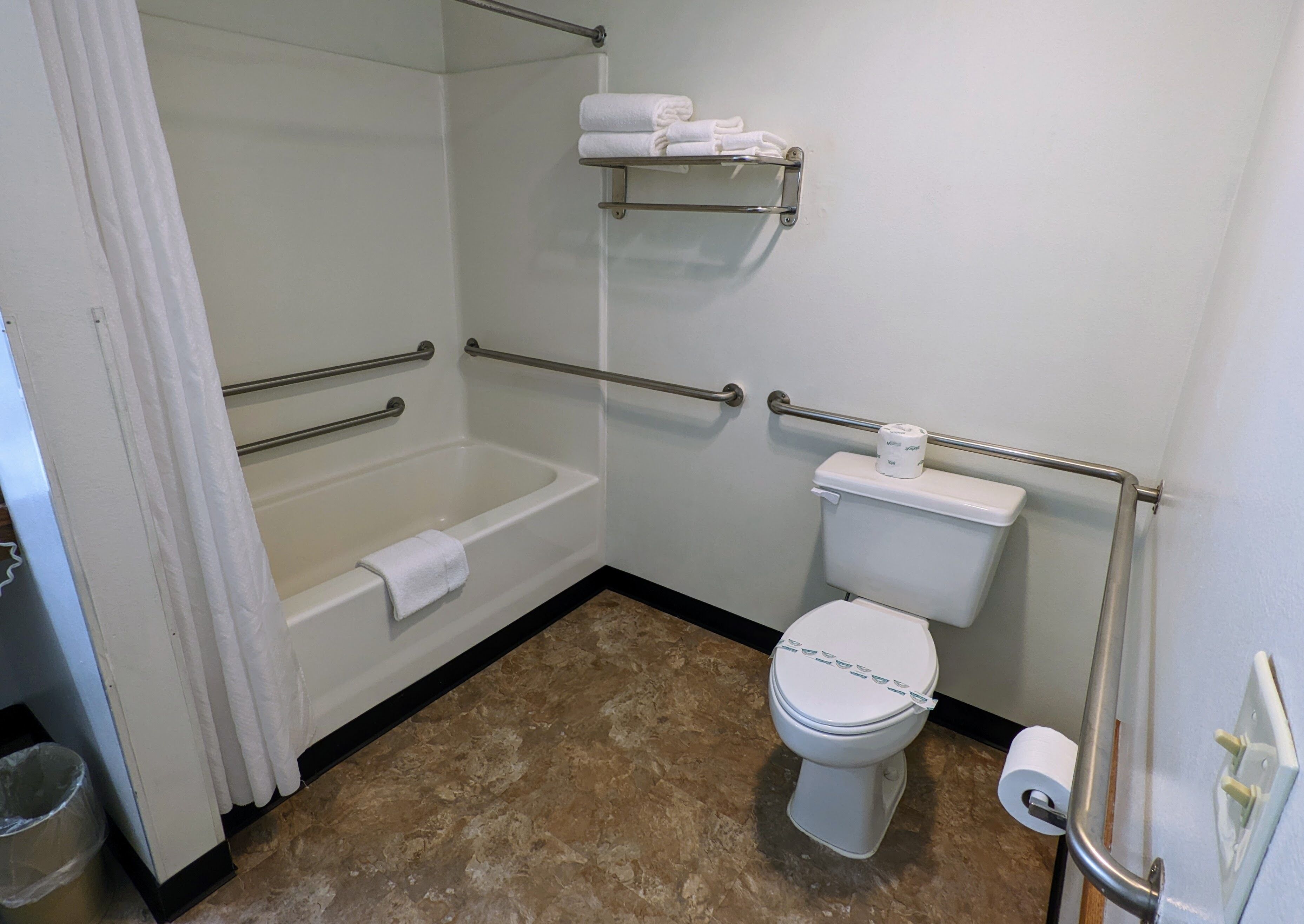 A bathroom with a bathtub, toilet, and shower.