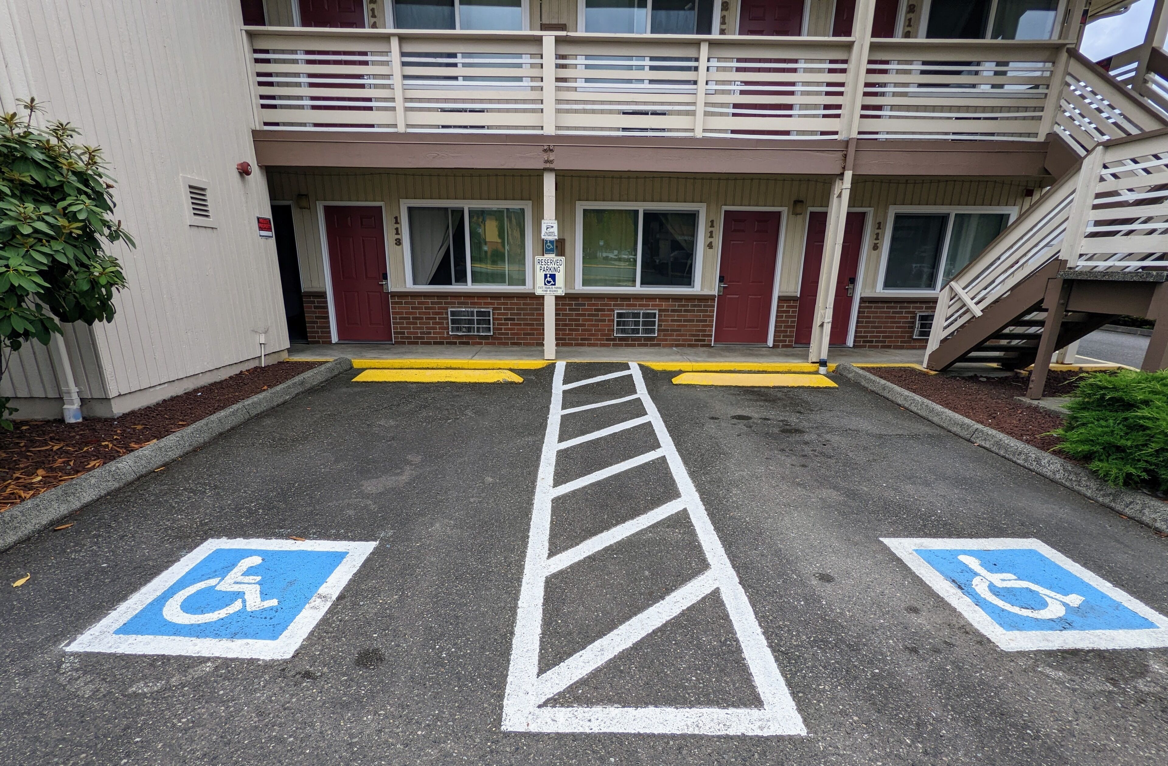 Een parkeerplaats met twee parkeerplaatsen voor gehandicapten, aangeduid met blauwe en witte symbolen.