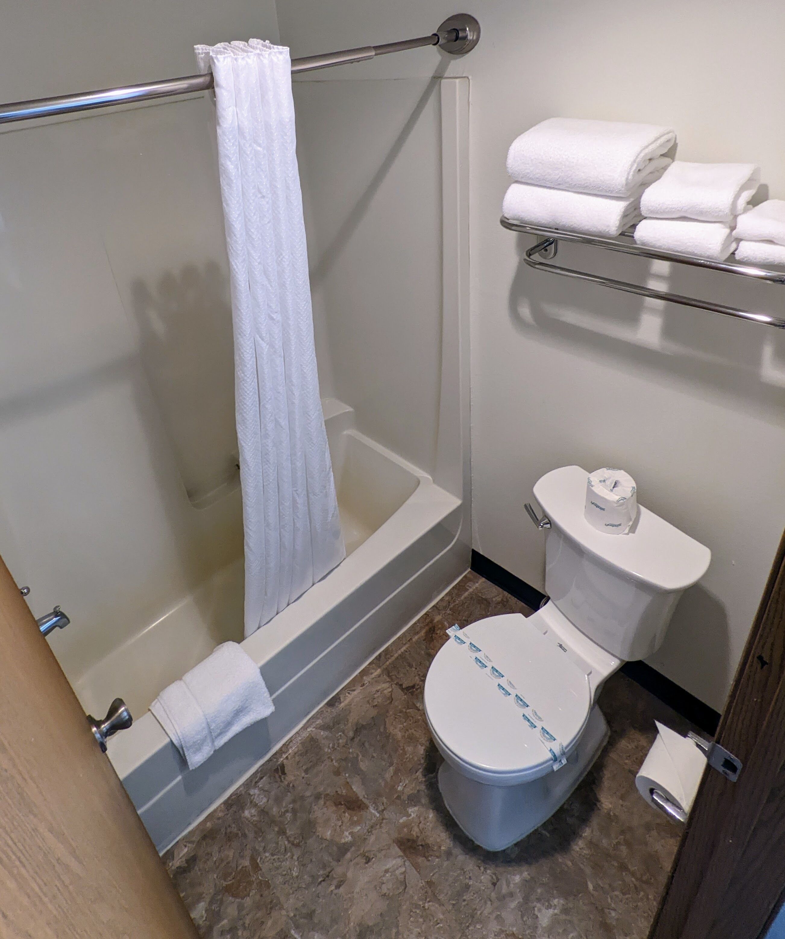 Une salle de bain avec une douche, des toilettes et un porte-serviettes.