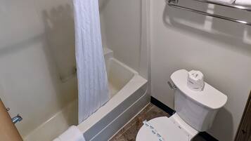 Une salle de bain avec une douche, des toilettes et un porte-serviettes.