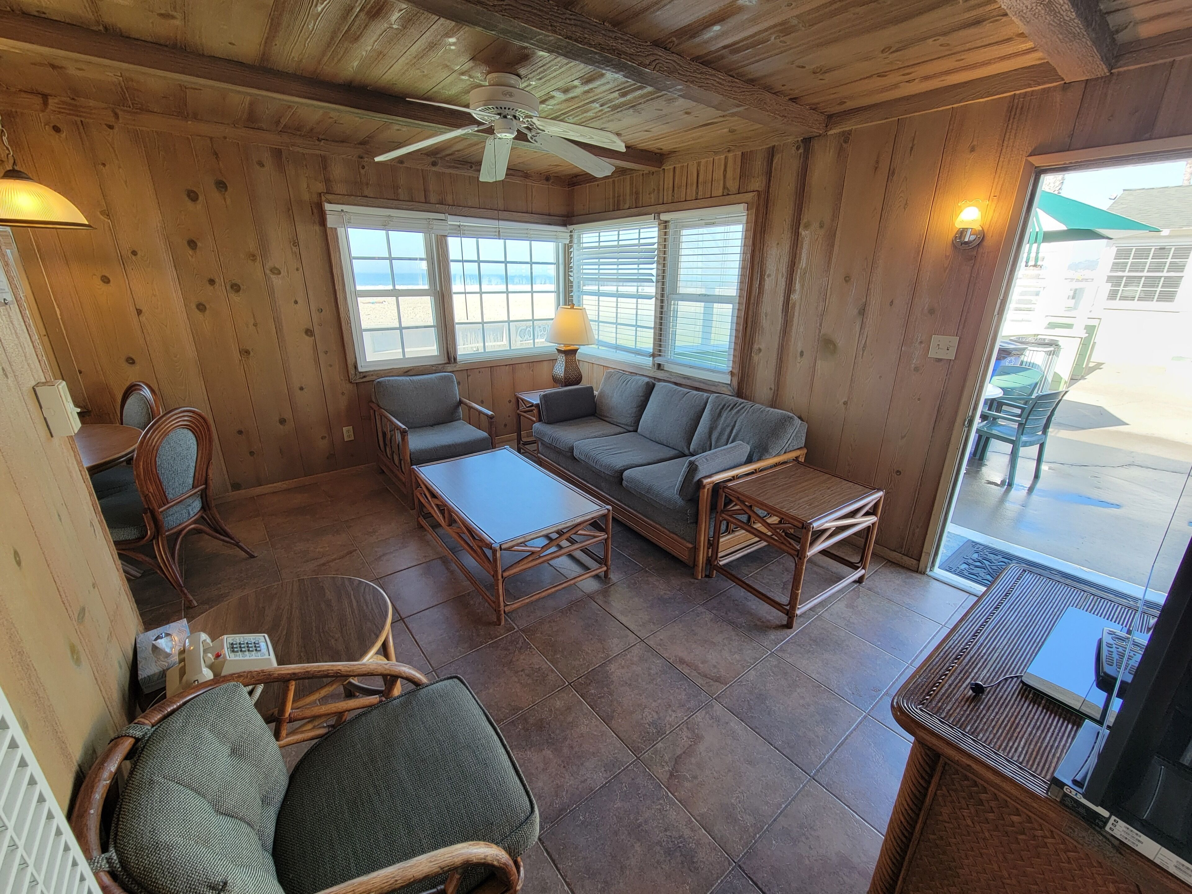 A wooden interior with a sofa, chairs, and a table.