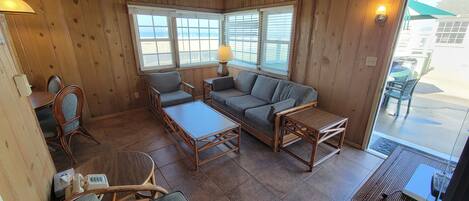 A wooden interior with a sofa, chairs, and a table.