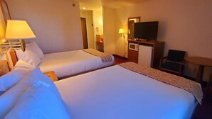 A hotel room with two beds, a television, a desk with a computer, and a small table with chairs. - Gettysburg Inn & Suites (Gettysburg)