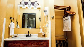 A bathroom with a sink, mirror, towel rack, and a hairdryer.