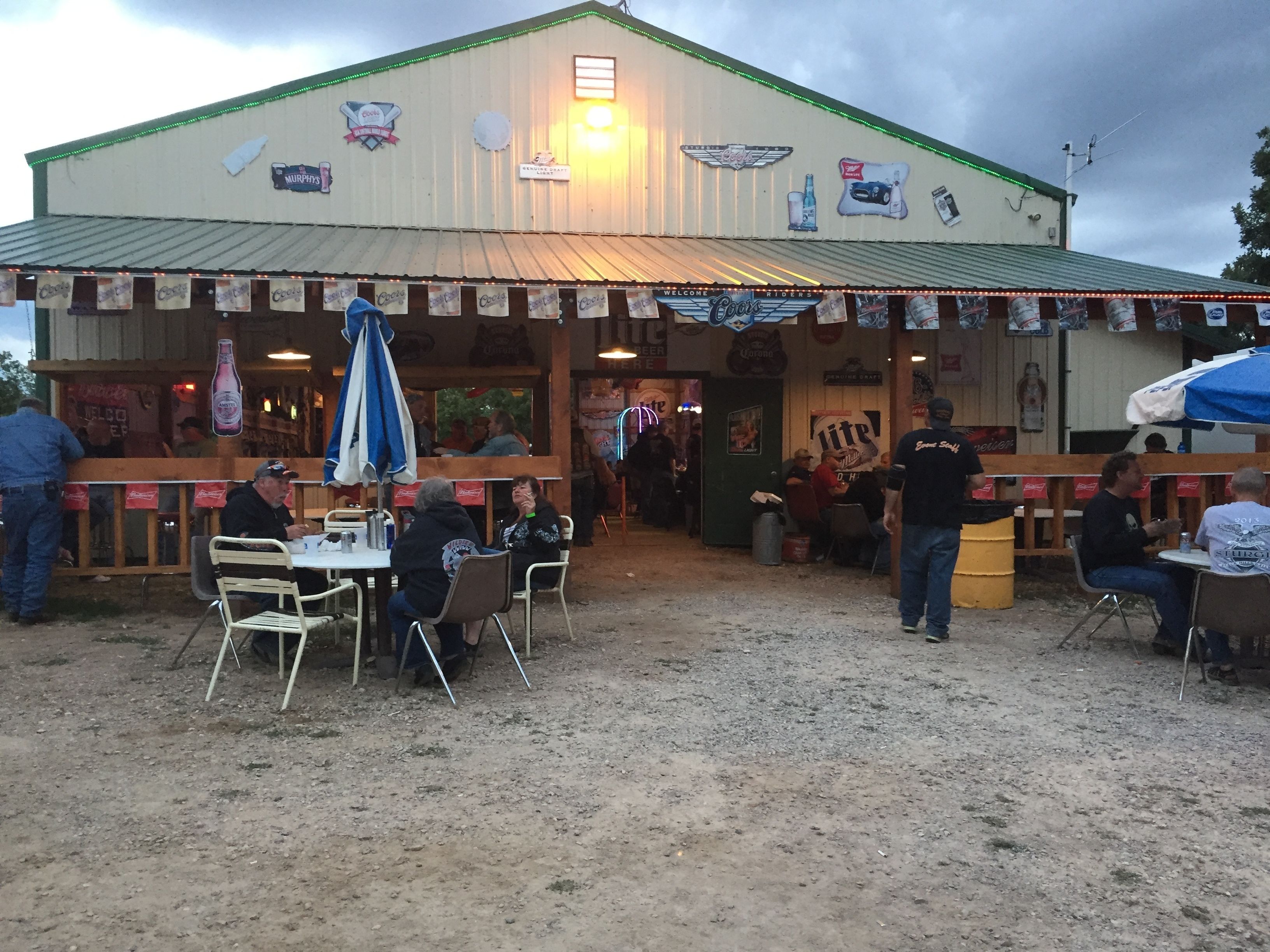 Ein Restaurant im Freien mit einem Erdboden, Metalltischen und -stühlen.