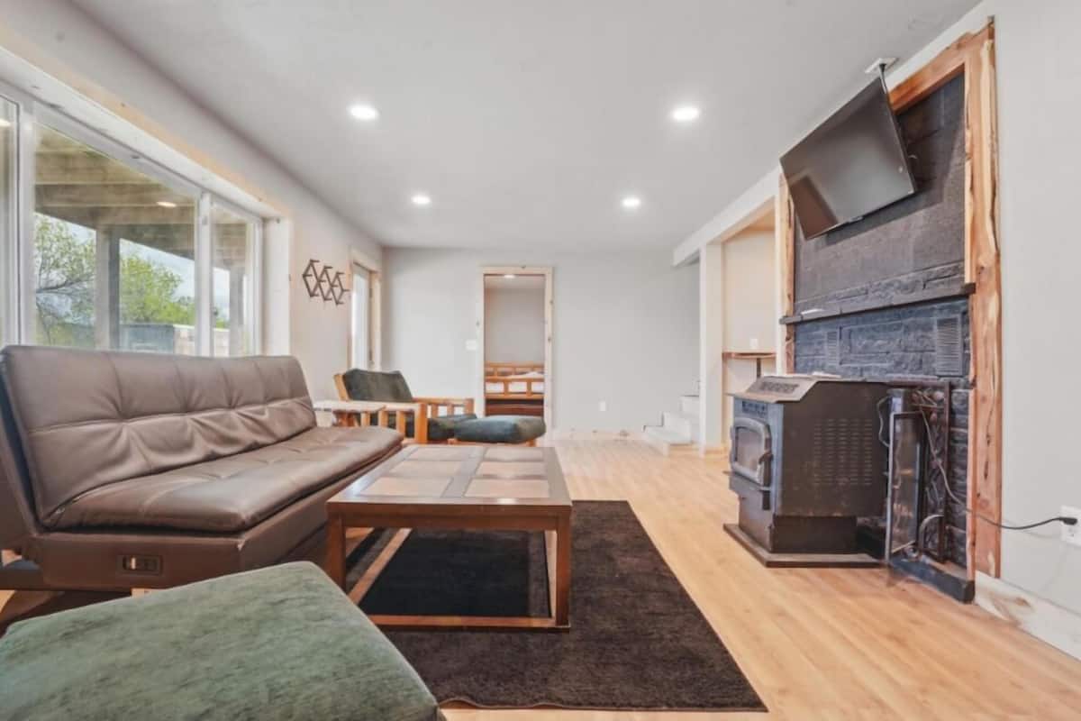 A modern living room with a leather sofa, a wooden coffee table, and a fireplace.