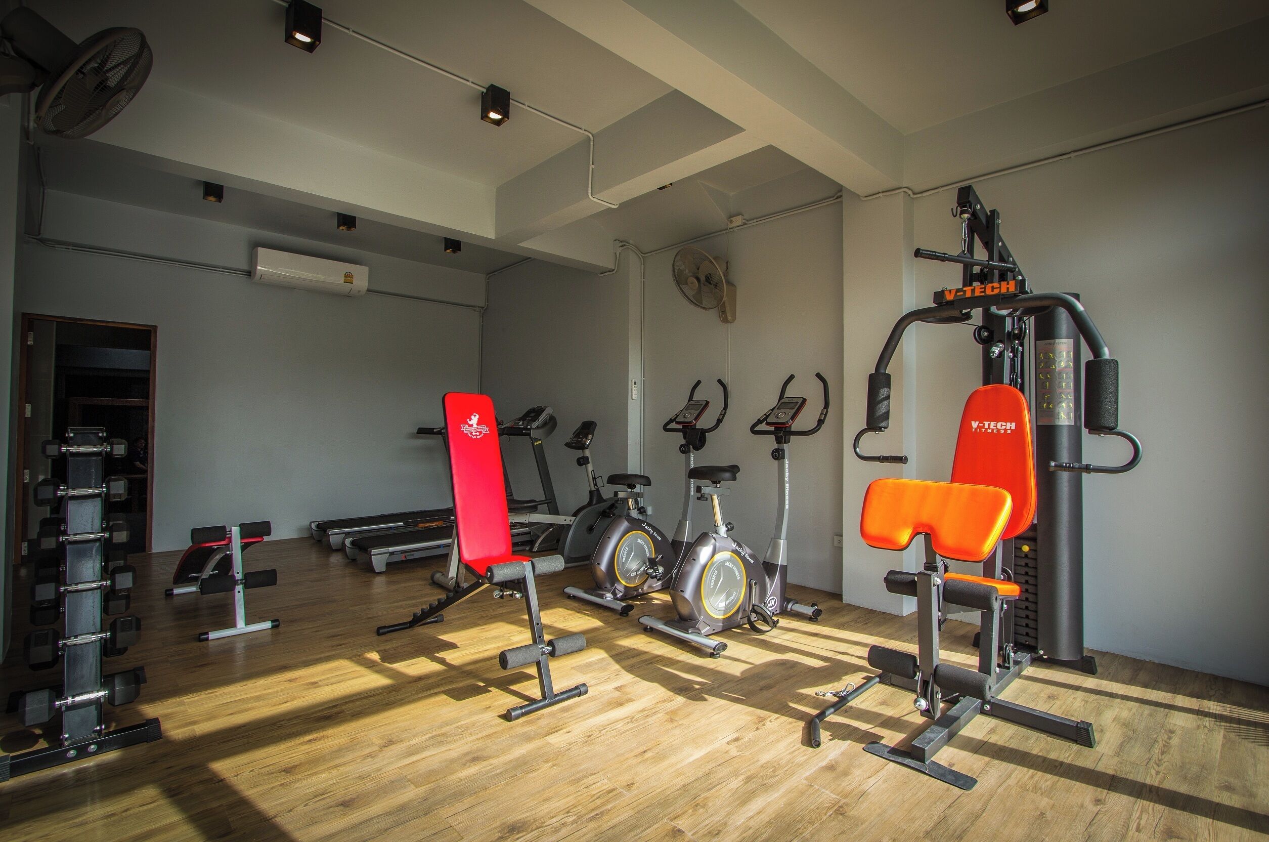 A gym with exercise equipment, including treadmills, stationary bikes, and weight machines.