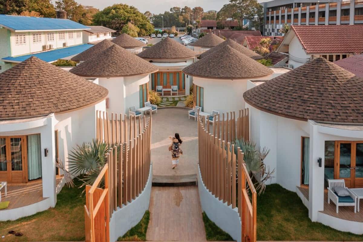 A resort with multiple bungalow-style buildings, each with a conical roof and a central courtyard.