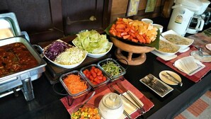 A buffet table with various food items and utensils.