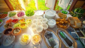 A buffet table with various food items and utensils.