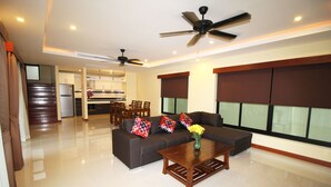 A modern living room with a sofa set, a coffee table, and a ceiling fan. - Bang Saray Pool Villa by Pattaya Sunny Rentals (Sattahip)