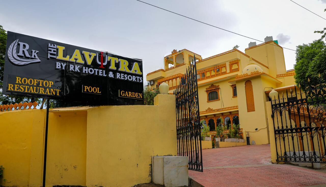 A sign for 'Rk Lavutra by Rk Hotel & Resorts' with amenities listed: Rooftop Restaurant, Pool, and Garden.
