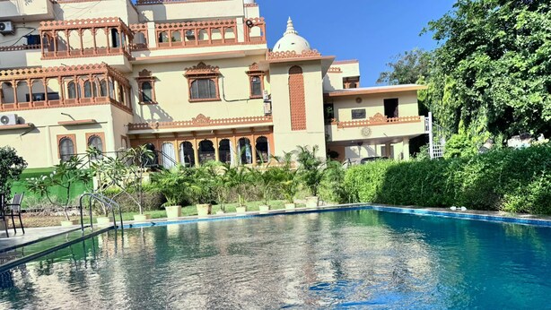 Una piscina con un edificio tradicional al fondo.