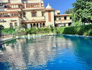 A swimming pool with a traditional building in the background.
