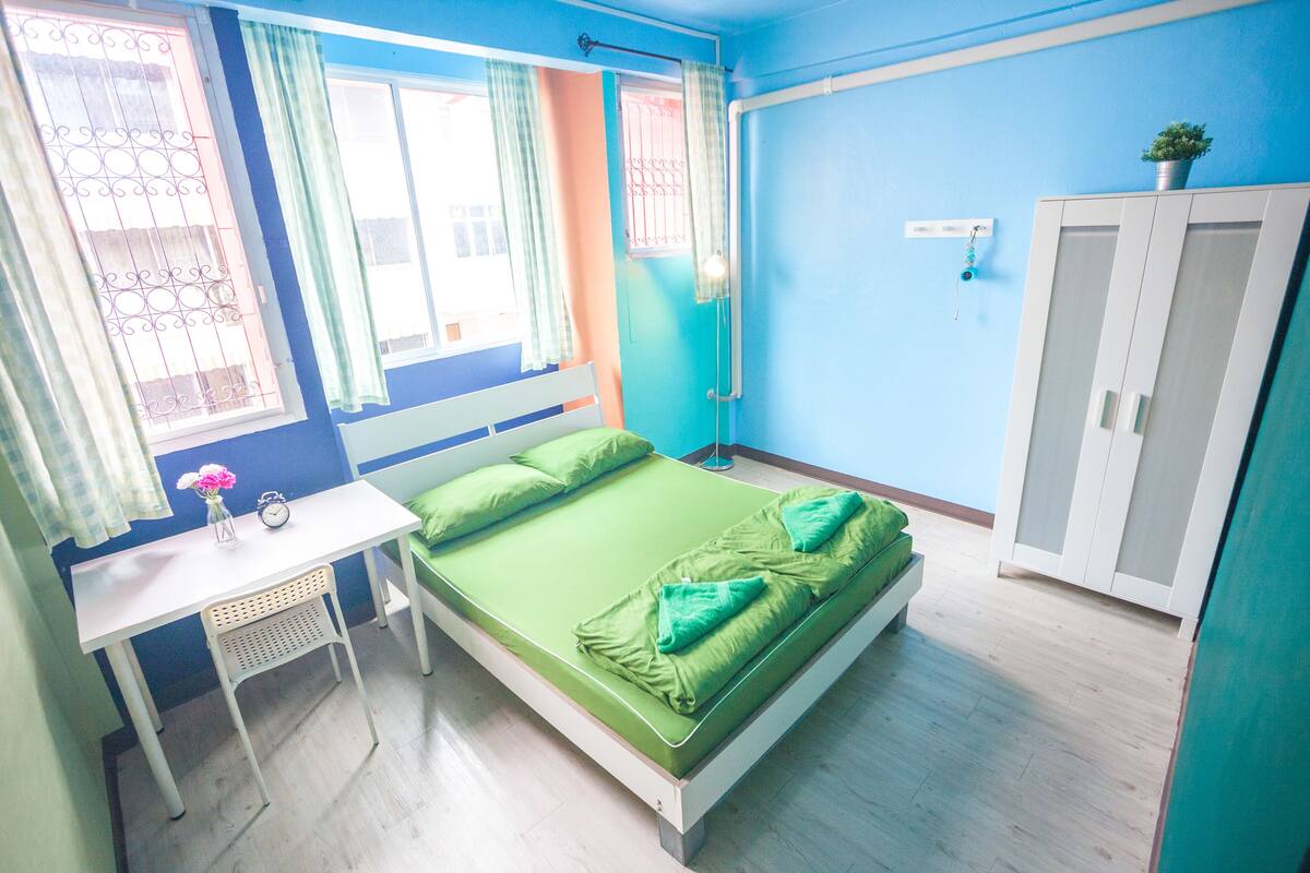 Une chambre avec un lit, un bureau et une armoire.