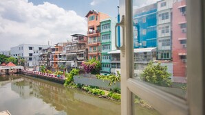 Une vue de bâtiments aux couleurs vives le long d’un canal, avec un pont au premier plan.