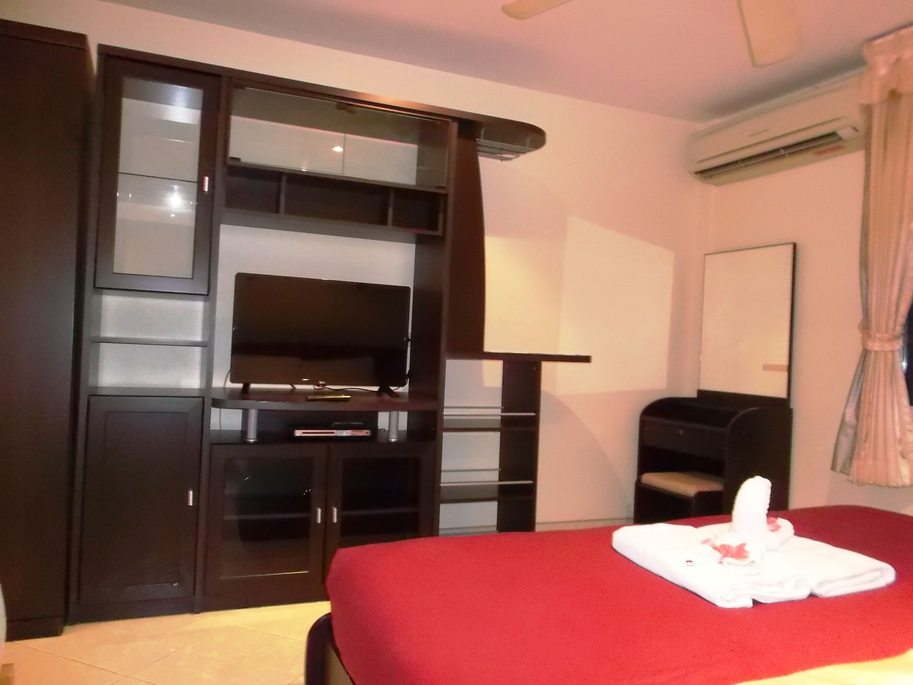 A hotel room with a bed, a TV, a desk, and a wardrobe.