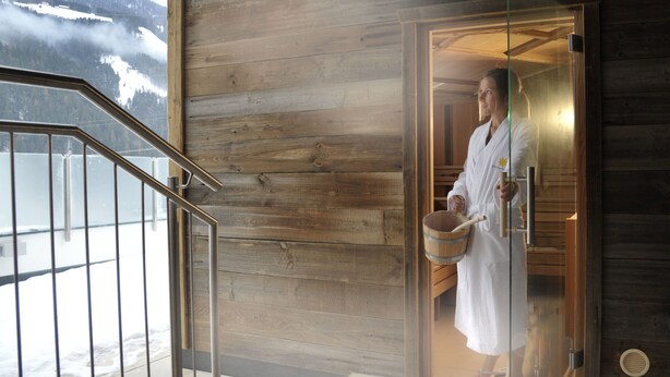 A wooden cabin with a glass door leading to a room.