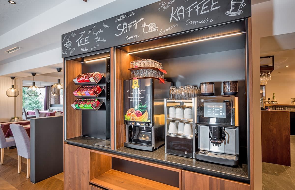 Ein Kaffee-Bereich mit einer Auswahl an Getränken, darunter Tee, Kaffee und Espresso, sowie verschiedenen Zusätzen.