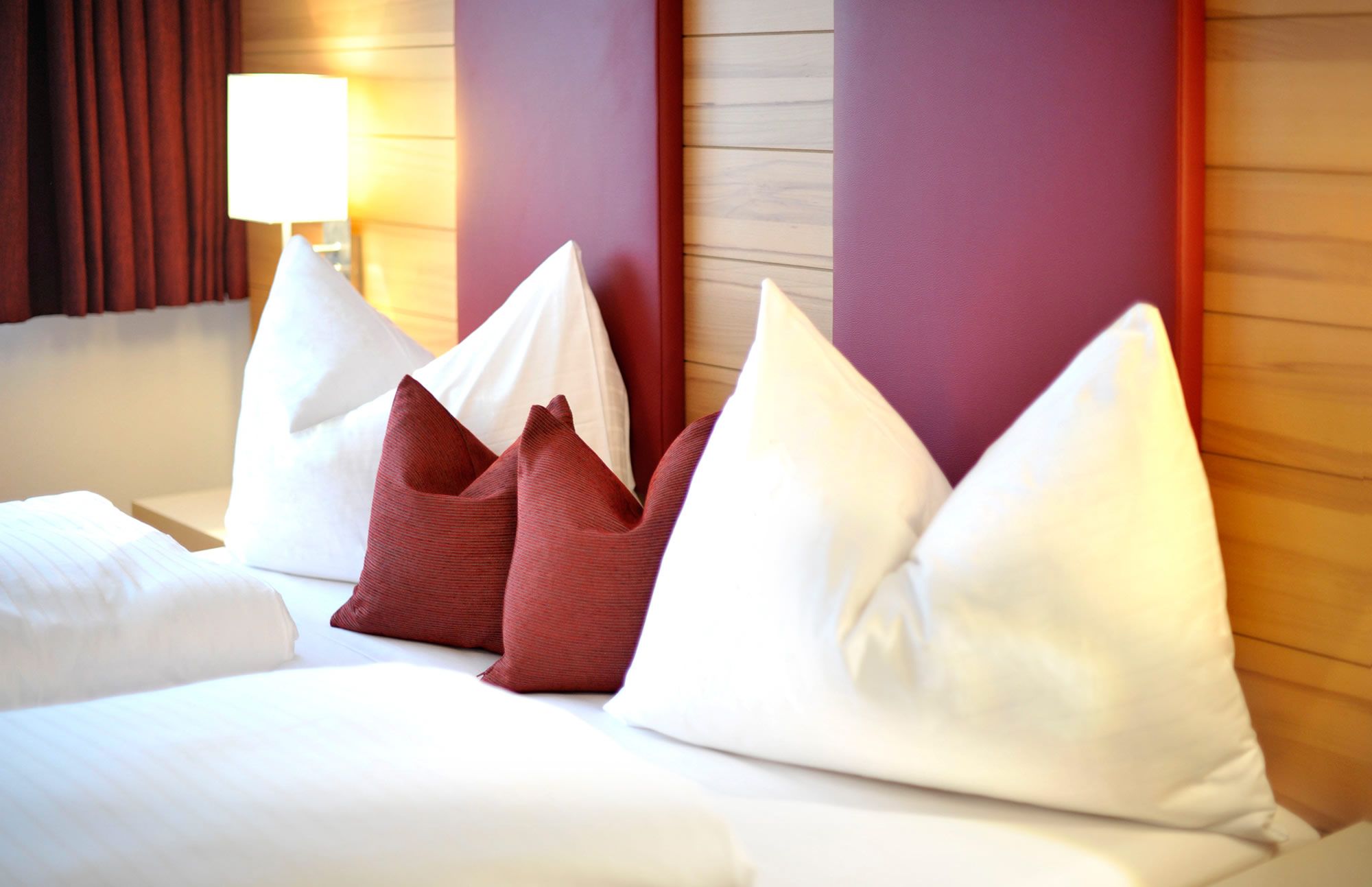 Une chambre d’hôtel avec un lit, des oreillers et une lampe.