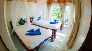 Two wooden beds with white linens and blue towels, a ceiling fan, and a view of greenery outside. - Bubble Bungalow (Koh Tao)
