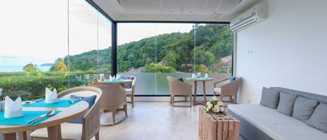A modern outdoor lounge area with a dining table, chairs, and a sofa.