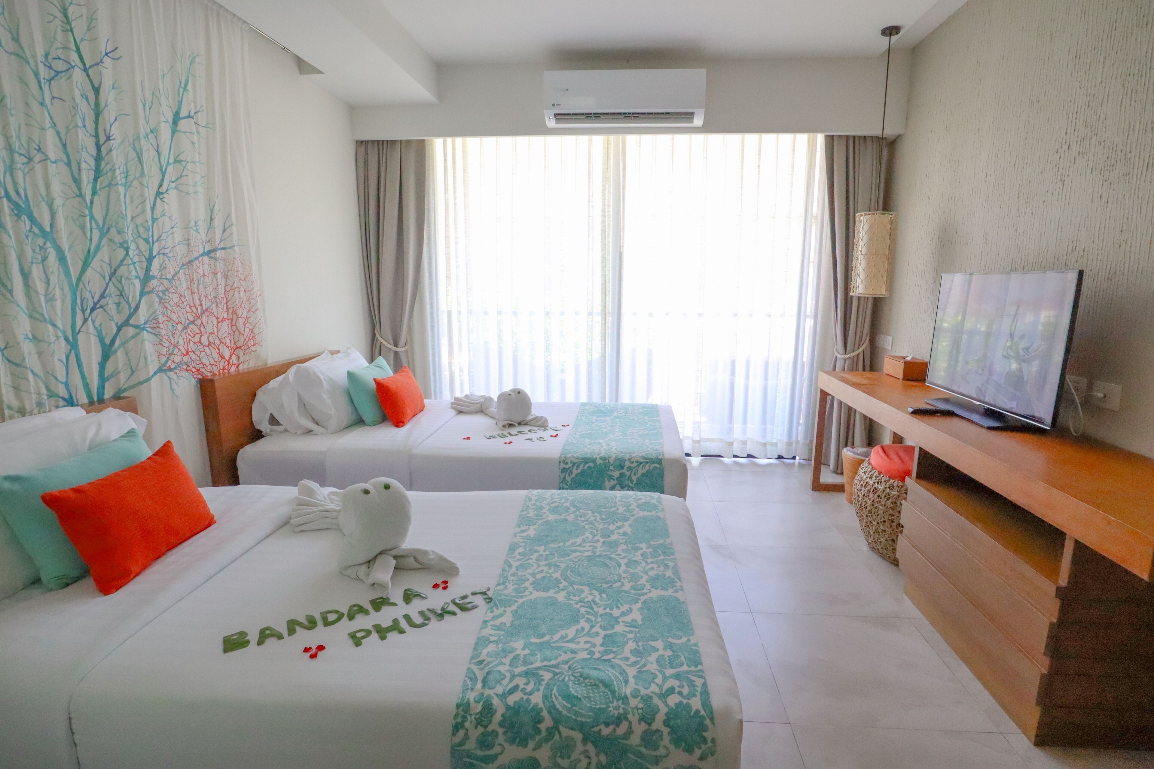 Una habitación de hotel con dos camas, un televisor y un escritorio.