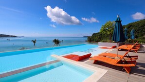 A clear blue swimming pool with lounge chairs and umbrellas, overlooking a calm sea and lush greenery. - Bandara Beach Resort, Phuket (Wichit)