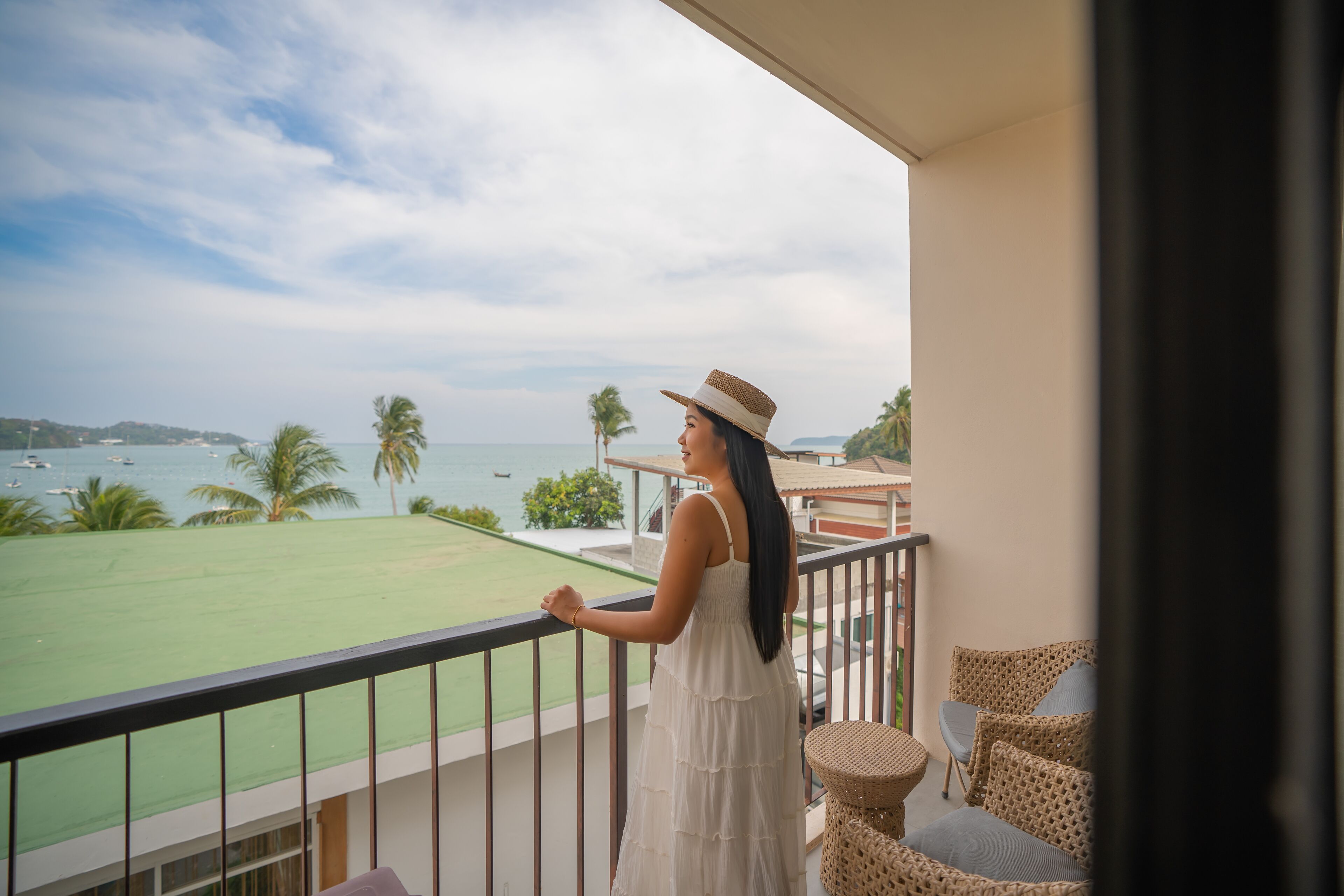 A balcony with a view of the sea and a lawn.