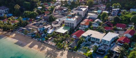 An aerial view of a coastal town with buildings, a beach, and a body of water.