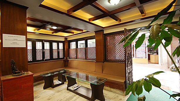 A traditional room with a wooden ceiling, a glass table, and a seating area. - Hotel Bubo Himalaya (Kathmandu)