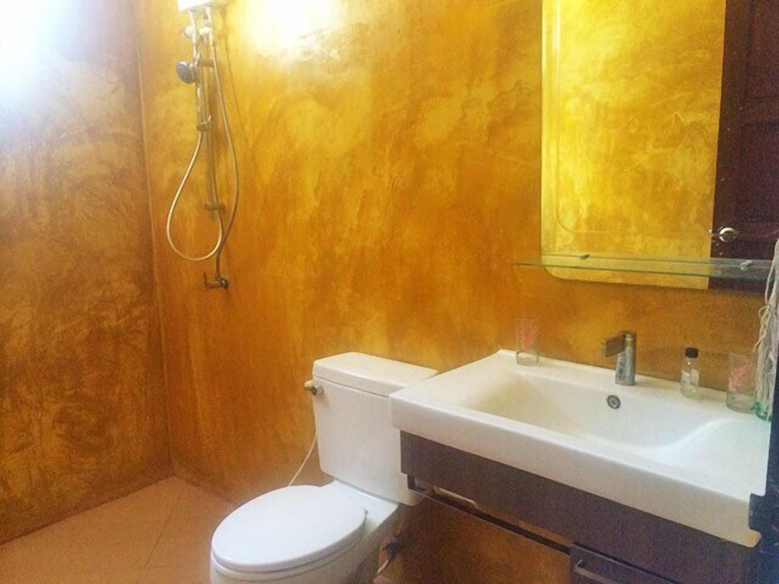 A bathroom with a toilet, sink, and mirror.