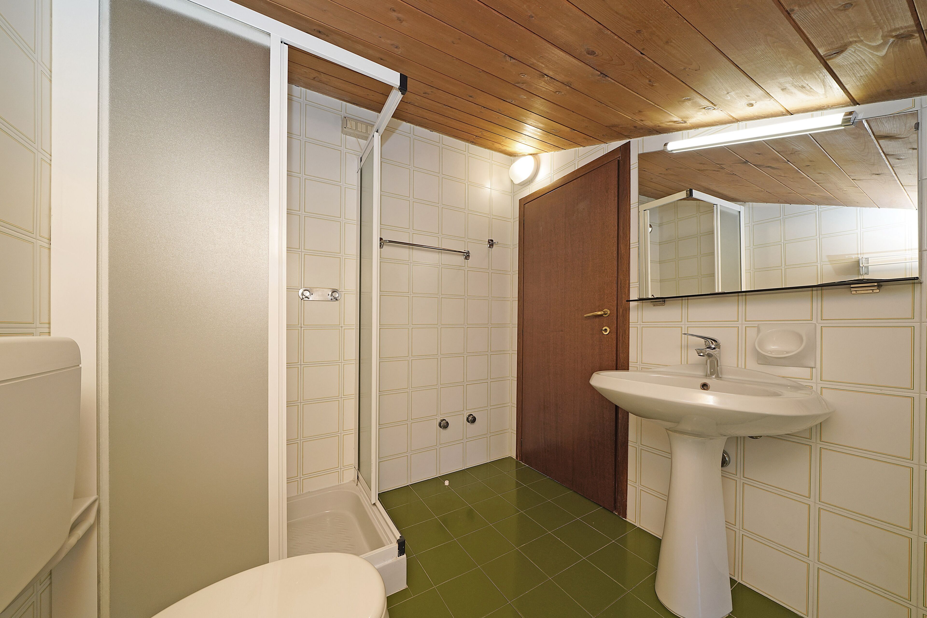 A bathroom with a shower, toilet, and sink.