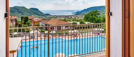 Un área de piscina con vistas a un pueblo y colinas.
