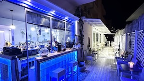 Une cuisine moderne avec un coin bar, une terrasse en bois et un espace salon extérieur.
