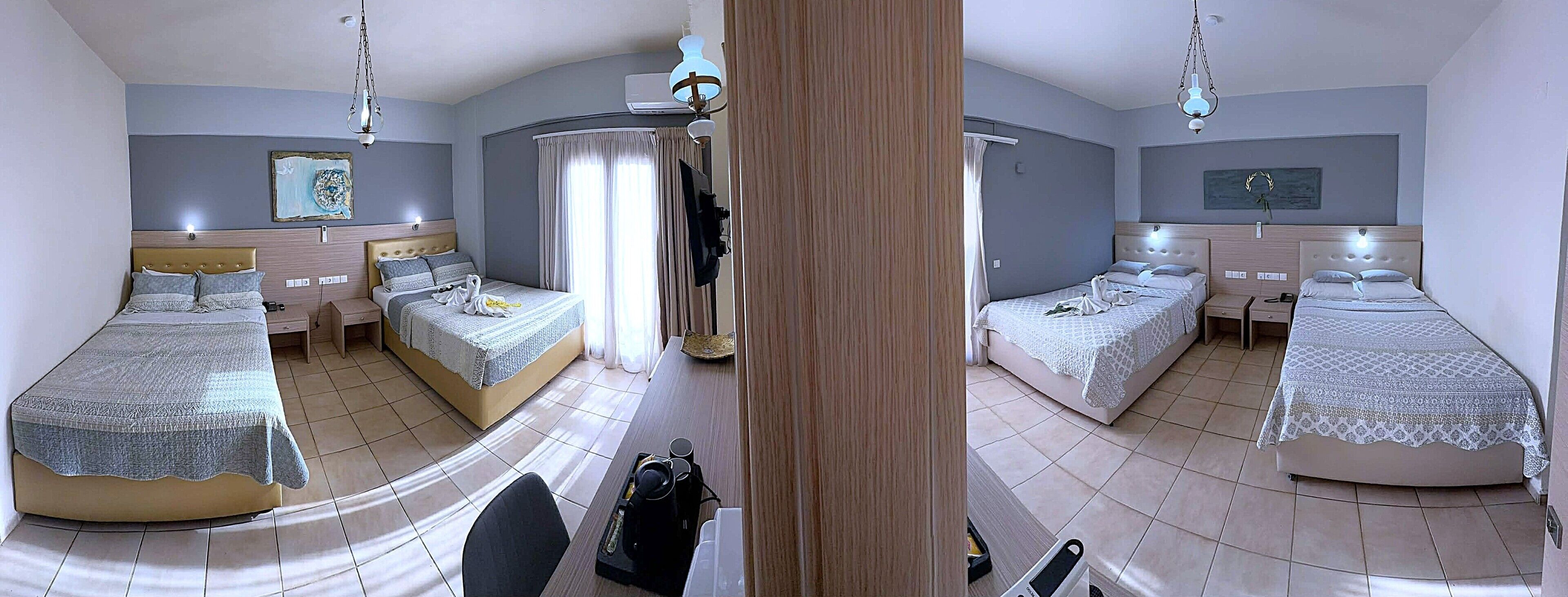 A hotel room with two beds, a desk, a chair, a wardrobe, and a bathroom.