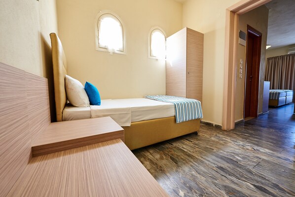 Una habitación de hotel moderna con cama, un banco de madera y un armario.