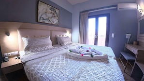 Une chambre d’hôtel comprenant un lit, une table de chevet, une lampe, un tableau, une fenêtre avec des rideaux et un appareil de climatisation.