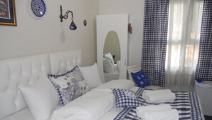 A neatly made bed with a checkered bedspread, white pillows, and a blue and white pillow. - Yacht House Istanbul (Istanbul)