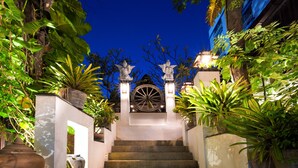 A staircase leading to a building entrance, surrounded by lush greenery and decorative lighting. - Yotaka Boutique Hotel Bangkok (Bangkok)