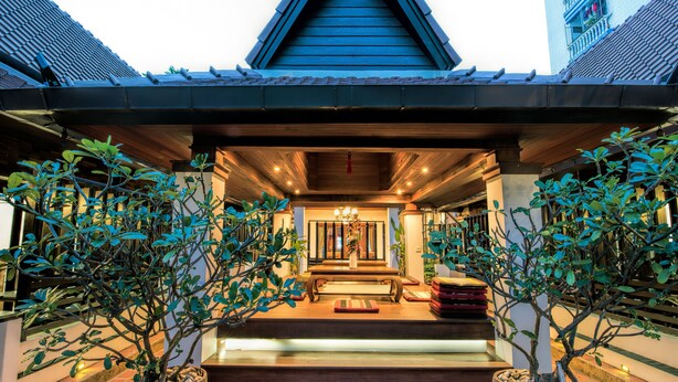 A traditional building with a steeply pitched roof, wooden beams, and a central entrance with steps leading up to a door. - Yotaka Boutique Hotel Bangkok (Bangkok)