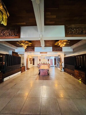 A spacious lobby with a central wooden table, flanked by dark wooden paneling and decorative ceiling elements. - Yotaka Boutique Hotel Bangkok (Bangkok)