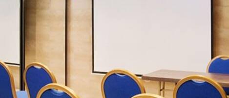 A conference room with blue chairs and a whiteboard.