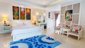 A modern hotel room with a large bed, two bedside tables, a desk, a chair, and a blue area rug. - Nantrungjai Boutique Hotel (Nan)