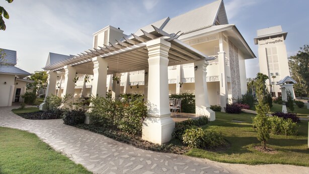 A hotel with a covered outdoor area, a stone pathway, and well-maintained landscaping. - Nantrungjai Boutique Hotel (Nan)